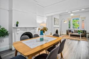 sala de estar con mesa de madera y sillas en Beautiful & Ultra Convenient 4-bdrm Terrace en Sídney