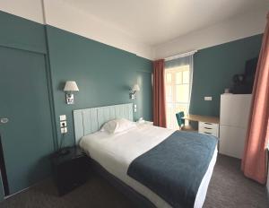 a bedroom with a bed and a blue wall at Logis Hôtel Ker Mor in Perros-Guirec