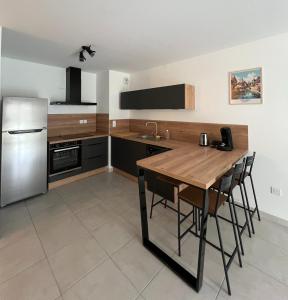 uma cozinha com uma mesa de madeira e um frigorífico em Le Stan - proche centre ville - Terrasse & Parking gratuit em Colmar