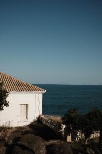 a white building on a hill next to the ocean at Luminoso piso cerca de la playa in Cullera
