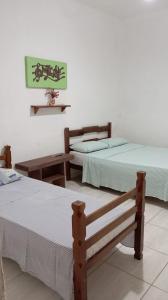 twee bedden naast elkaar in een kamer bij Pousada Fazendinha in Camburi