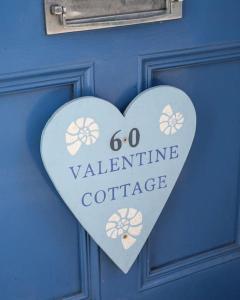 a heart sign on a blue door with the words go valentine coffee at Holiday Cottage with Seafront Beach Hut, Lyme Regis, Dorset in Lyme Regis