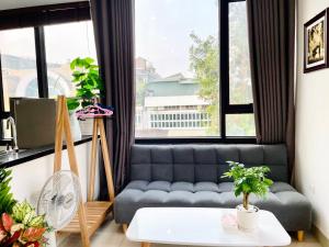 uma sala de estar com um sofá em frente a uma janela em Kem Apartment 18 Ngô Quyền em Hanói