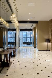 a lobby with tables and chandeliers in a building at Bomonti Arjaan by Rotana in Istanbul