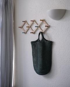 a black bag hanging on a wall with hangers at Holiday Cottage with Seafront Beach Hut, Lyme Regis, Dorset in Lyme Regis