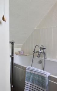 a bathroom with a bath tub with a towel on it at Holiday Cottage with Seafront Beach Hut, Lyme Regis, Dorset in Lyme Regis