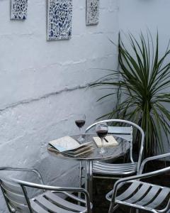 a table with two glasses of wine and a book at Holiday Cottage with Seafront Beach Hut, Lyme Regis, Dorset in Lyme Regis