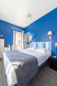 a bedroom with a large bed with blue walls at Logis Hôtel Ker Mor in Perros-Guirec