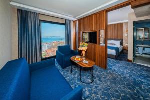a hotel room with a blue couch and a table at Ring Stone Hotels Bosphorus - Special Class in Istanbul