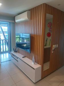 Habitación con TV y barra con espejo. en Cupe Beach Living Concept 304E, en Porto de Galinhas