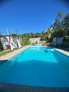 uma grande piscina com água azul em Chalé Por do Sol em Caruaru