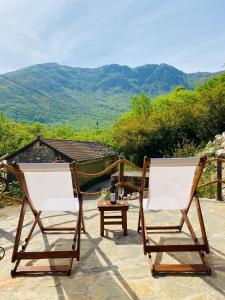 2 sillas y una mesa en un patio con montañas en Skadar Lake Aparment Nikola II en Virpazar
