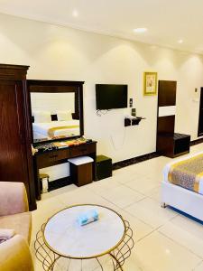 una camera d'albergo con letto e soggiorno di Rose Wood a Taif