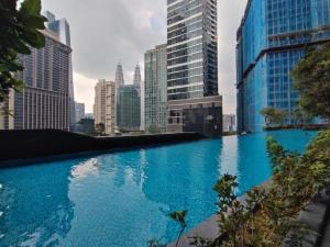 een zwembad in een stad met hoge gebouwen bij ASTRA @ 8 Kia Peng Suites in Kuala Lumpur