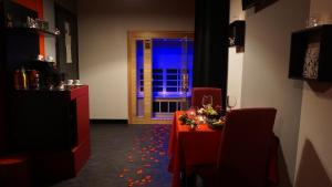 ein Esszimmer mit einem roten Tisch und einem Fenster in der Unterkunft Il Cantuccio Suite in Salsomaggiore Terme