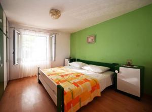 a green bedroom with a bed and a window at Apartments Mihovilovic - 50 m from beach in Slatine +42 photos