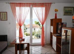 a living room with a large window with red curtains at Apartments Mihovilovic - 50 m from beach in Slatine