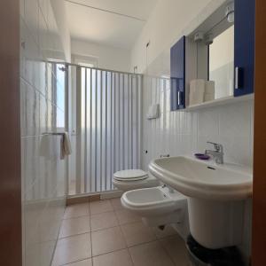 bagno bianco con lavandino e servizi igienici di Hotel Immagine a San Giovanni Rotondo