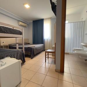 una camera d'albergo con due letti e un bagno di Hotel Immagine a San Giovanni Rotondo