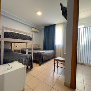 a bedroom with two bunk beds and a bathroom at Hotel Immagine in San Giovanni Rotondo