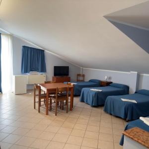 a room with two beds and a table and chairs at Hotel Immagine in San Giovanni Rotondo