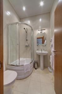 a bathroom with a shower and a toilet and a sink at Solo Isaac Square in Saint Petersburg