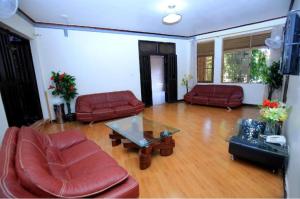 uma sala de estar com mobiliário vermelho e uma mesa de vidro em Lake view property em Kisubi