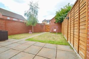 a backyard with a fence and a goal at 3 Bedroom House in Kent by AV Stays in Sittingbourne