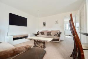 a living room with a couch and a table at 3 Bedroom House in Kent by AV Stays in Sittingbourne