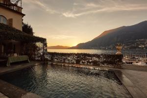 una piscina junto a un edificio con vistas al agua en Luxury Villa Tesoro & pool, en Torno