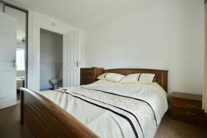 a bedroom with a large bed with white sheets and pillows at 3 Bedroom House in Kent by AV Stays in Sittingbourne