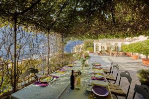 una mesa larga con platos y botellas de vino. en Luxury Villa Tesoro & pool, en Torno