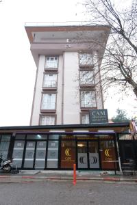 wysoki biały budynek z napisem w obiekcie Çam Suit w Kahramanmaras
