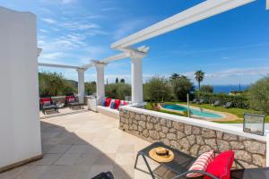 a patio with a stone wall and a swimming pool at Villa Serenity garden & pool in Anacapri