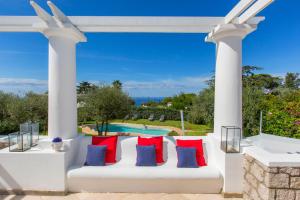a white pergola with red and blue pillows at Villa Serenity garden & pool in Anacapri