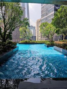 a large pool of blue water in a city at ASTRA @ 8 Kia Peng Suites in Kuala Lumpur