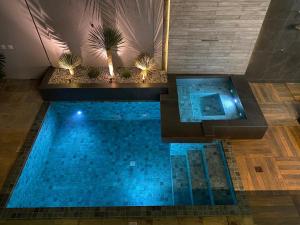 a swimming pool with blue water in a building at Casa com Piscina no bairro João VI, Muriaé-MG in Muriaé