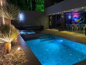 a swimming pool in a backyard at night at Casa com Piscina no bairro João VI, Muriaé-MG in Muriaé