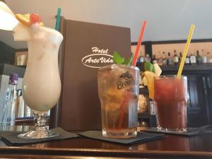 tres bebidas sentadas en una mesa en un bar en Hotel Arte Vida OHG, en Spremberg