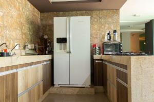a white refrigerator in a kitchen with wooden cabinets at Casa com Piscina no bairro João VI, Muriaé-MG in Muriaé