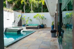 a pool in the middle of a patio with plants at Casa com Piscina no bairro João VI, Muriaé-MG in Muriaé