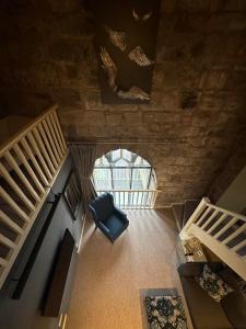 Cette chambre dispose d'une chaise et d'un escalier. dans l'établissement Pottergate Tower, à Alnwick
