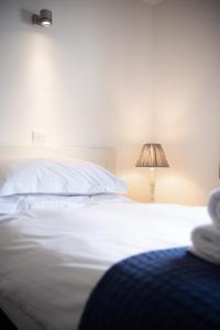 a bedroom with a white bed and a lamp at Trevose Golf and Country Club in Padstow