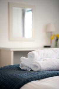 a pile of towels sitting on top of a bed at Trevose Golf and Country Club in Padstow