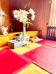 a table with a vase with flowers in it at Hospedaje Familiar Doña Juanita in Puerto Montt