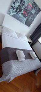 a bed with two pillows on top of it at Sleepy3city Władysława IV 50 in Gdynia