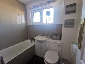 a bathroom with a sink and a toilet and a window at AW House in Edinburgh