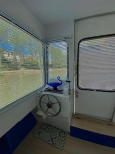 a bathroom with a toilet in a train with windows at Bateau Mama Mia in Narbonne