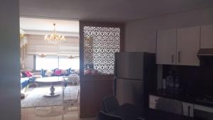 a kitchen and a living room with a refrigerator at Résidence Mansbay Rosa, Mohammedia in Mohammedia