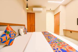 a bedroom with a bed with a colorful blanket on it at FabHotel DC Premium in Zirakpur
